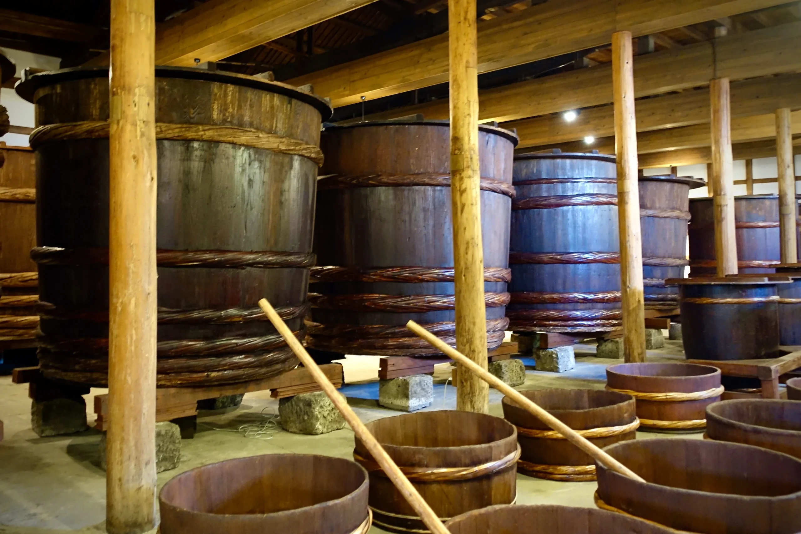 Wooden barrels lined inside a traditional Japanese sake brewery