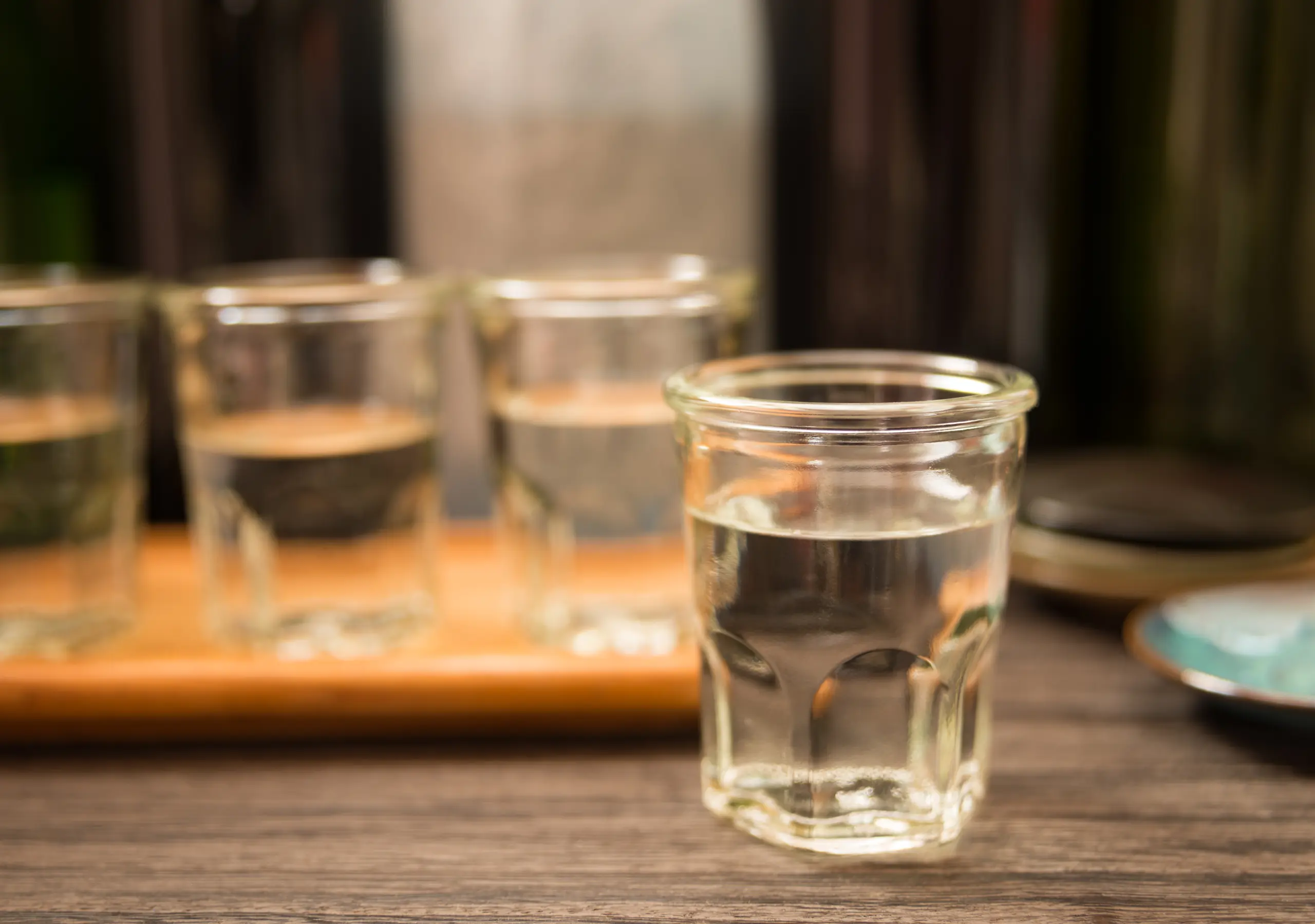 Small cups of Japanese sake arranged for a tasting flight.