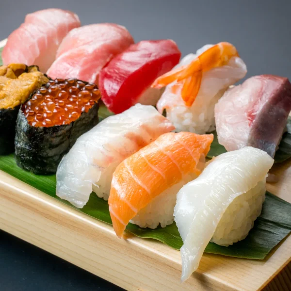 Traditional nigiri sushi assortment with uni, salmon, shrimp, and tuna