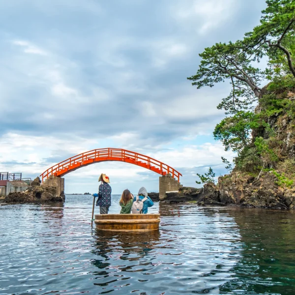 Traditional tub boat ride near red bridge in Sado Island, Niigata